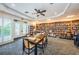 Well-lit library with tables and chairs surrounded by walls lined with built-in shelving units containing books at 1009 Almondwood Dr, Trinity, FL 34655