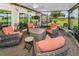 Inviting screened-in patio featuring a fire pit and comfortable seating for entertaining at 1009 Almondwood Dr, Trinity, FL 34655