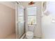 Full bathroom offering a glass enclosed shower, toilet, and natural light from the window at 10285 Rosetti Ct, Spring Hill, FL 34608