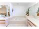 Bright bathroom featuring a soaking tub with tile surround and double sink vanity at 10285 Rosetti Ct, Spring Hill, FL 34608