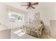 Cozy bedroom featuring a ceiling fan, closet, and large window overlooking the front yard at 10285 Rosetti Ct, Spring Hill, FL 34608