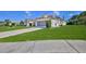 Well-maintained home with a lush green lawn and a long driveway leading to the garage at 10285 Rosetti Ct, Spring Hill, FL 34608