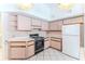 Traditional kitchen with pink cabinetry, white appliances, and ceramic tile flooring at 10285 Rosetti Ct, Spring Hill, FL 34608