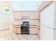 Traditional kitchen with pink cabinetry, white appliances, and ceramic tile flooring at 10285 Rosetti Ct, Spring Hill, FL 34608