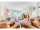 Bright living room with cozy seating near a fireplace, a window, and a built in bookshelf at 10285 Rosetti Ct, Spring Hill, FL 34608