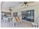 Cozy covered patio area with fans, dining table, and poolside views through sliding glass doors at 10285 Rosetti Ct, Spring Hill, FL 34608