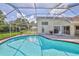 Clear, blue pool in a screened enclosure, showcasing the home's backyard and outdoor living space at 10285 Rosetti Ct, Spring Hill, FL 34608