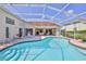 Inviting pool in screened enclosure with patio, lounge chairs, and views of the house at 10285 Rosetti Ct, Spring Hill, FL 34608