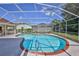 Sparkling screened-in pool featuring a brick coping, surrounded by a patio and manicured lawn at 10285 Rosetti Ct, Spring Hill, FL 34608