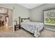 Bright bedroom with a window view, features a floral patterned bed and a small side table with lamp at 11101 Ragsdale Ct, New Port Richey, FL 34654