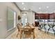 Inviting dining area with wood table, chairs, and view into the kitchen with dark cabinetry and tile flooring at 11101 Ragsdale Ct, New Port Richey, FL 34654
