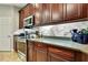 Well-equipped kitchen with stainless steel appliances, granite counters, and abundant dark wood cabinet storage at 11101 Ragsdale Ct, New Port Richey, FL 34654