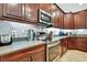 Gourmet kitchen features stainless steel appliances, a marble backsplash, and dark wood cabinetry at 11101 Ragsdale Ct, New Port Richey, FL 34654