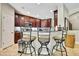 Kitchen bar with granite counters, dark cabinetry, stainless appliances, and three decorative metal bar stools at 11101 Ragsdale Ct, New Port Richey, FL 34654
