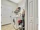 Functional laundry room features a modern washer and dryer with storage shelves for supplies and tiled flooring at 11101 Ragsdale Ct, New Port Richey, FL 34654