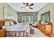 Spacious bedroom featuring a decorative ceiling fan, dresser, and a large framed piece of art at 11101 Ragsdale Ct, New Port Richey, FL 34654