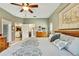 Comfortable bedroom with a king bed, ceiling fan, ensuite bath, and hallway to other rooms at 11101 Ragsdale Ct, New Port Richey, FL 34654