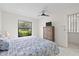 Bright bedroom features a ceiling fan, large window with a view, and light carpet at 11621 Pear Tree Dr, New Port Richey, FL 34654