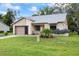 Charming one-story home with a garage, manicured lawn, and flowering plants at 11621 Pear Tree Dr, New Port Richey, FL 34654