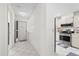 Hallway with kitchen access, featuring stainless steel appliances and white cabinets at 11621 Pear Tree Dr, New Port Richey, FL 34654