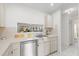 Well-lit kitchen featuring stainless steel dishwasher, sink, and a pass-through window at 11621 Pear Tree Dr, New Port Richey, FL 34654