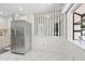 Bright kitchen area featuring a stainless steel refrigerator and white tile floors at 11621 Pear Tree Dr, New Port Richey, FL 34654