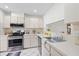 Bright kitchen with modern stainless appliances, ample counter space, and white cabinets at 11621 Pear Tree Dr, New Port Richey, FL 34654