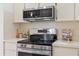 Close-up of modern stainless steel appliances and neutral countertops in a well-lit kitchen at 11621 Pear Tree Dr, New Port Richey, FL 34654