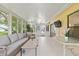 Enclosed sunroom bathed in natural light with tile flooring and comfortable seating at 11621 Pear Tree Dr, New Port Richey, FL 34654
