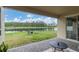 Relaxing backyard views from covered lanai with lake views, a tranquil seating area, and lush green grass at 11876 Ranchers Gap Dr, Odessa, FL 33556