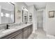 Bathroom featuring double sinks, granite countertops, and modern fixtures at 11876 Ranchers Gap Dr, Odessa, FL 33556