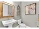 Charming half bathroom featuring a pedestal sink, decorative mirror, and stylish wall decor at 11876 Ranchers Gap Dr, Odessa, FL 33556