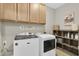Efficient laundry room with overhead cabinets, appliances, laundry sign and organized shelving at 11876 Ranchers Gap Dr, Odessa, FL 33556