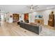 Spacious living room featuring light hardwood floors, modern furniture, and recessed lighting at 11876 Ranchers Gap Dr, Odessa, FL 33556