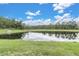 Beautiful view of a large pond with lush greenery, clear reflection and cloudy skies at 11876 Ranchers Gap Dr, Odessa, FL 33556