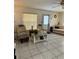 Bright living room with neutral tile flooring, large windows, and comfortable seating at 12104 Boynton Ln, New Port Richey, FL 34654