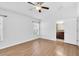 Bright bedroom with wood floors, ceiling fan, large windows, and an adjoining bathroom at 13600 Crest Lake Dr, Hudson, FL 34669