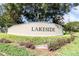 Welcoming community entrance sign for Lakeside, showcasing lush landscaping and mature trees, creating a serene atmosphere at 13600 Crest Lake Dr, Hudson, FL 34669