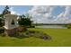 Beautiful entrance to community with pristine landscaping and lovely lake views on a sunny day with fluffy clouds at 13600 Crest Lake Dr, Hudson, FL 34669