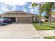 Charming, single-story home featuring a 2-car garage, manicured lawn and attractive landscaping, perfect for suburban living at 13600 Crest Lake Dr, Hudson, FL 34669