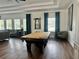 Spacious game room featuring a pool table, hardwood floors, and large windows at 13600 Crest Lake Dr, Hudson, FL 34669
