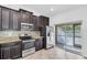 Modern kitchen equipped with stainless steel appliances, granite countertops, and dark wood cabinets, offering style and functionality at 13600 Crest Lake Dr, Hudson, FL 34669