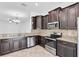 Modern kitchen with stainless steel appliances, granite countertops, and dark cabinetry, perfect for cooking and entertaining at 13600 Crest Lake Dr, Hudson, FL 34669