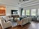 Well-lit and spacious living room featuring hardwood floors, modern furniture, and large windows at 13600 Crest Lake Dr, Hudson, FL 34669