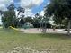 Outdoor community playground with a slide and swings in a landscaped area surrounded by trees and grass at 13600 Crest Lake Dr, Hudson, FL 34669