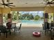 Community pool with a zero entry surrounded by lounge chairs and tables at 13600 Crest Lake Dr, Hudson, FL 34669