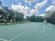 Outdoor community tennis court with lush landscaping and a scenic backdrop on a beautiful day at 13600 Crest Lake Dr, Hudson, FL 34669