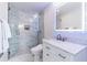 Bathroom with marble walk-in shower, white cabinets, and vanity with a lighted mirror at 1365 Snell Isle Ne Blvd # 1B, St Petersburg, FL 33704