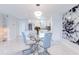 Bright dining area with marble floors, modern lighting fixture, and kitchen with white cabinets in the background at 1365 Snell Isle Ne Blvd # 1B, St Petersburg, FL 33704