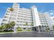 A full exterior view of the condo building with palm trees, manicured landscaping and circular decorative patterns at 1365 Snell Isle Ne Blvd # 1B, St Petersburg, FL 33704